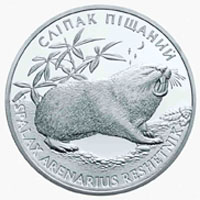 Photograph of a coin depicting a rodent with plants in the left background surrounded by Cyrillic script.