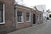 Seminarie der oude Clerezy. Hoog oprijzend huis van drie verdiepingen met rechte kroonlijst, aan de korte zijden topgevels. Terzijde strekt een lager gebouw zich uit met ingangspartij, geblokte pilasters en tympaan