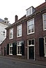 Pand, deel uitmakend van rij aaneengeschakelde 19e-eeuwse huizen, in bocht van de singel gelegen onder een rechte daklijst. Harmonische raamverdeling met luiken