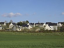 Lotissement de maisons de construction récente, aux toits d'ardoises bleue et aux murs blancs