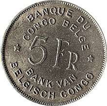 Une pièce ronde argentée portant les mentions « Banque du Congo belge. 5 Fr. Bank van Belgisch Congo. »