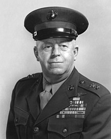 Black-and-white photo of a white man in his Marine Corps uniform. He is wearing a hat, his military awards and 2 star general rank insignia.