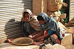 Des jeunes filles trient des grains de café dans un marché éthiopien.