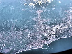 The area around Carrara, seen from an aircraft flying at 10,000 metres. The town is at the top of the picture, nearest to the سنگ مرمر quarries which are the white markings on the mountains.