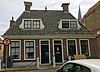 Woning onder schilddak met hoekschoorsteen waarop borden