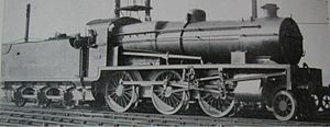 Side-and-front view of a 3-cylinder 2-6-0. The distinguishing feature is a full-width flat panel rising vertically above the front buffer beam to the level of the bottom of the smokebox door.