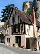 Photographie en couleurs d'une maison dont les murs portent des colombages en bois.