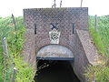 Sluis door de dijk nabij de molen.