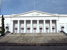 A white building with a triangular facade and wide stairs