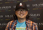 A picture of an Asian man who wears glasses and smilles.