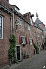 Pand, deel uitmakend van groep van vijf woningen. Statige hoge gevel met steil zadeldak. Aan de singelzijde gemetselde bogen en lisenen