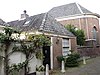 Woonhuis met lage gevel uitgevoerd in baksteen. Maakt deel uit van het synagoge-complex