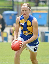 Female athlete holding an Australian rules football