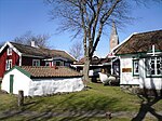 Öckerö hembygdsgård med nya kyrkan i bakgrunden.