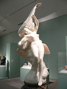 Photograph of a marble sculpture of a naked woman whose head is sheltered by the outstretched wing of an eagle