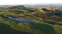 An aerial photo of hills and a lake