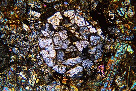 Porphyrisches Pyroxen-Chondron im Dünnschliff, gekreuzte Polarisatoren