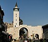 A tripartite Roman city gate with a minaret on its right side