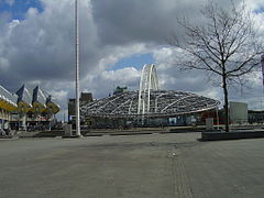 bâtiment de gare bordé par des maisons à gauche et un arbre à droite