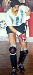 Photographie d'un joueur de rink hockey sur ses patins avec un maillot blanc et bleu