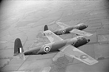 Photographie en noir et blanc de deux avions militaires en plein vol