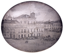 Photograph showing the Imperial Palace in Rio de Janeiro with carriages and mounted honor guard in the square fronting the palace