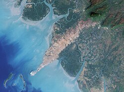 Conakry NASA:n Landsat-satelliittikuvassa (vuodelta 2000). Tiiviisti asuttu Kaloumin niemimaa erottuu selvästi sitä ympäröivien mangrovekosteikkojen alueesta. Niemimaan lounaispuolella näkyvät Kaloumin kaupunginosaan kuuluvat Tombonsaari.