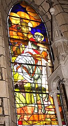 A stained-glass window, inside the church of Mayrac, of Saint Martin sharing his coat by Georges Lebacq