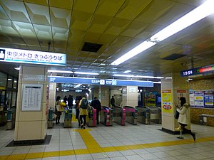 A train station ticket gate with passengers entering