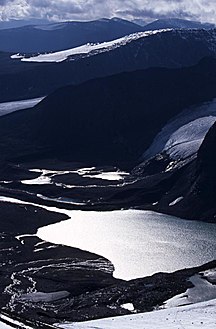 Tarfaladalen övre delen med Tarfalajaure och stugläget för STF-stugan skymtande vid utloppet. Isfallsglaciären bakom sjön. Fotot taget från Tarfalatjåkka 2003.