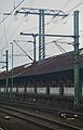 Tractiestroommast, door het dak van een opslagloods in het station van Fulda, Duitsland