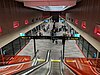 Picture of Hills Showground station. It consists of an underground platform with platform screen doors viewed from an escalator.