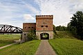 Seitenansicht des Brückenhauses; rechts im Bild der Bahndamm, links die Brücke