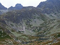 Prostredné Zbojnícke pleso, které se na snímku jeví jako dvě vodní plochy, vpředu před Vyšným Zbojníckym plesem