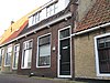 Vier woningen onder brede dwarskap tussen oude topgevels