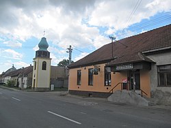 Hostinec a zvonice při hlavní silnici, směr Ždánice