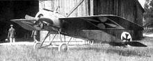 Photo noir et blanc d'un avion monoplan devant un hangar