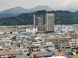 草薙駅周辺。高層ビルに挟まれた位置にJR草薙駅がある。左側の高層ビルはしずぎん本部タワー。すぐ右側の高層ビルはグラソード草薙(マークス・アネシスタワー草薙)。画面中央上部、コブのように連なる山が竜爪山。