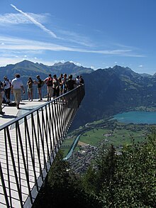 Mehrere Personen stehen auf einer stark ausgesetzten Aussichtsplattform.