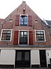 Pakhuis met topgevel en ovale vensters. Hijsbalk