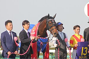 第84回皐月賞口取りにおける所有馬ジャスティンミラノ（左）と表彰式での三木（右）