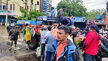 People rushing to get food and supplies from a distribution vehicle