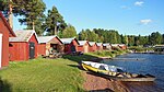 Båthus vid Siljans strand i Nusnäs. I bakgrunden skymtar folkparken Bliktpunkten. Foto: Frank Hüncke, 2013.