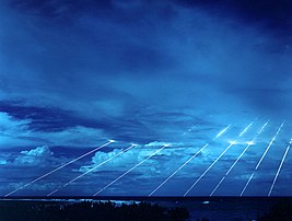 Test du missile balistique intercontinental américain LGM-118 Peacekeeper sur l’atoll de Kwajalein, dans les Îles Marshall. Le Peacekeeper était un missile mirvé, qui pouvait emporter jusqu’à dix véhicules de rentrée, chacun transportant une ogive de 300 kilotonnes (vingt fois la puissance de la bombe larguée sur Hiroshima). Sur cette photographie à long temps de pose, sont visualisées les trajectoires de rentrée dans l’atmosphère de huit têtes nucléaires. (définition réelle 3 000 × 2 272)