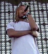 A man is rapping into a microphone while standing on a stage.