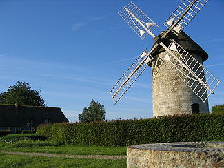 Une meule (en bas à droite), le moulin (à droite) et la maison du meunier (à gauche)