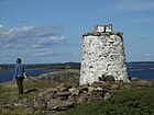 På øya Leistein står en hvitmalt varde av ukjent alder og viser innseiling til Vrengensundet. Foto: Karl Ragnar Gjertsen