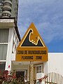 A bilingual sign (Spanish - English) that indicates a flood hazard zone in Iquique, Chile