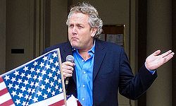 Photograph of Andrew Breitbart shrugging while speaking at an event