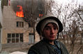 Sur cette photographie, l'innocence impuissante le cède au tragique, souligné par la maison en flammes.